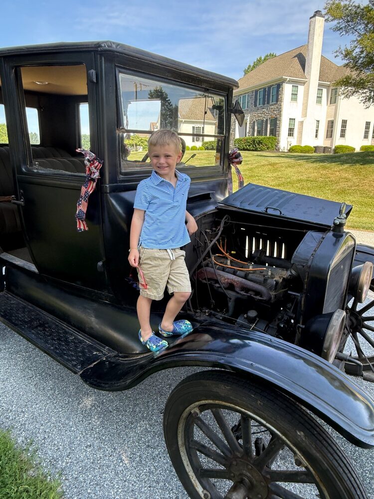 The engine cover of Curly open, a child on the running board