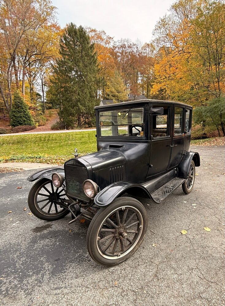 Curly, a black 1923 Ford Model T sedan, parked in the driveway among autumn trees
